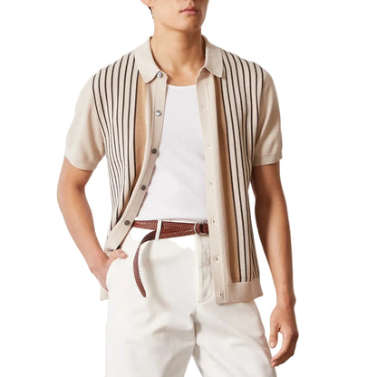 Person wearing a striped shirt over a white t-shirt with white pants on a light background