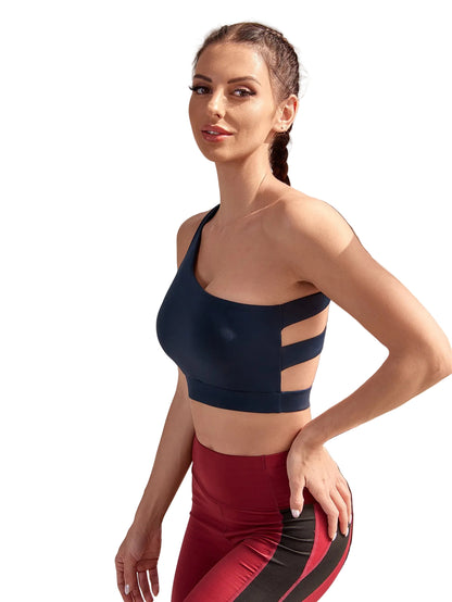 Woman wearing a black sports bra and red leggings in a bright indoor setting