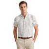 Man wearing a white and navy striped shirt with beige pants on a white background