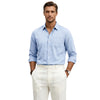 Man wearing a light blue shirt and white pants on a white background